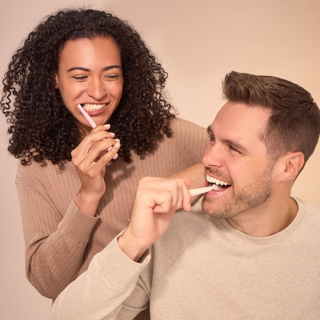 Woman and man brushing teeth