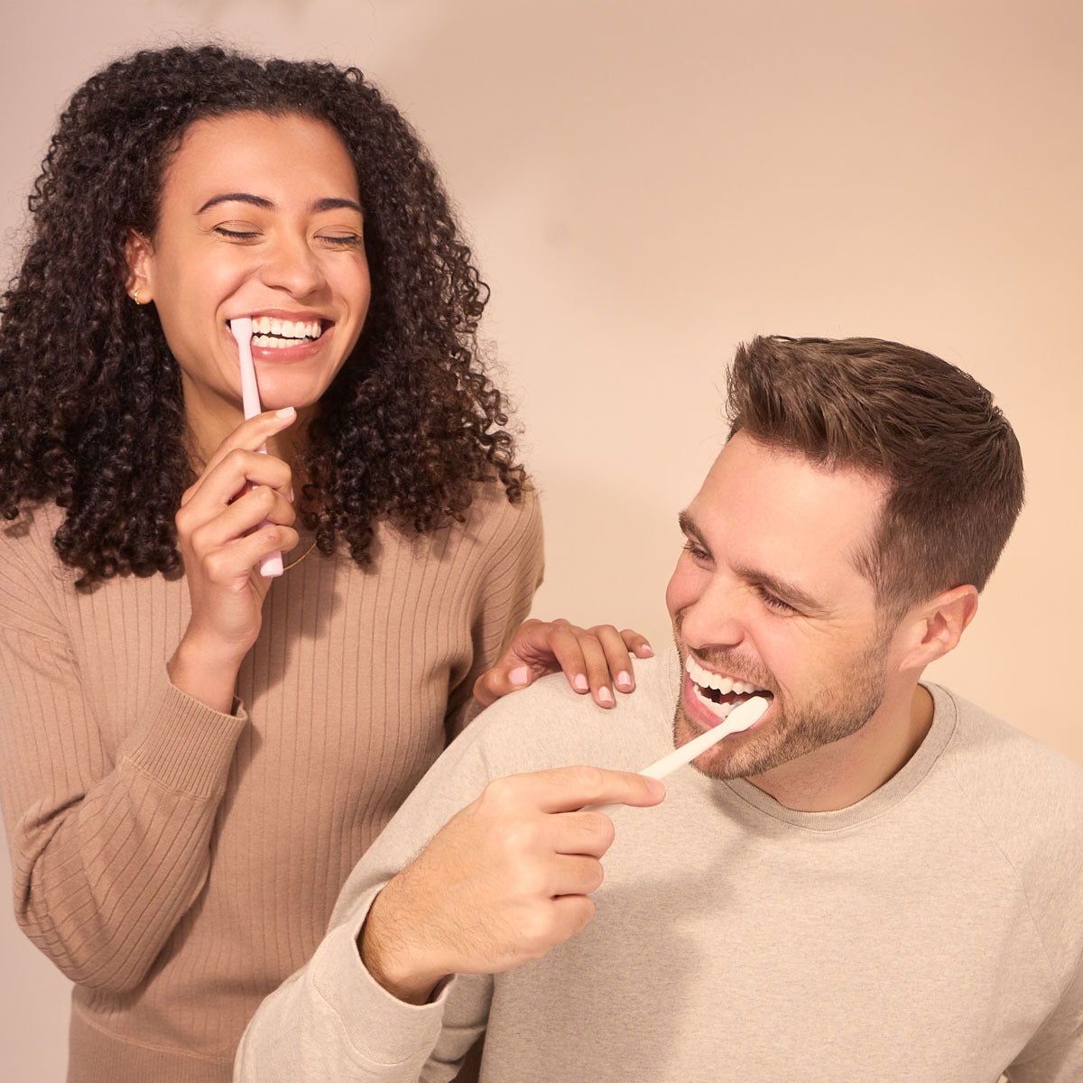 Woman and man brushing their teeth